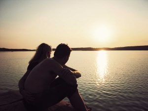 Par som myser i solnedgången på klipporna på hotell på Västkusten